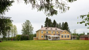 Ein großzügiges, zweistöckiges Haus mit einer überdachten Veranda und einem gepflegten Rasen.