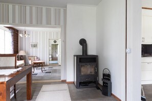 Quarto com lareira, mesa de jantar e vista para um corredor.