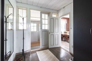 A room with a wooden floor, a white door, and a view of an outdoor dining area. - Historic countryside schoolhouse for gatherings, retreats & celebrations (Hartola)