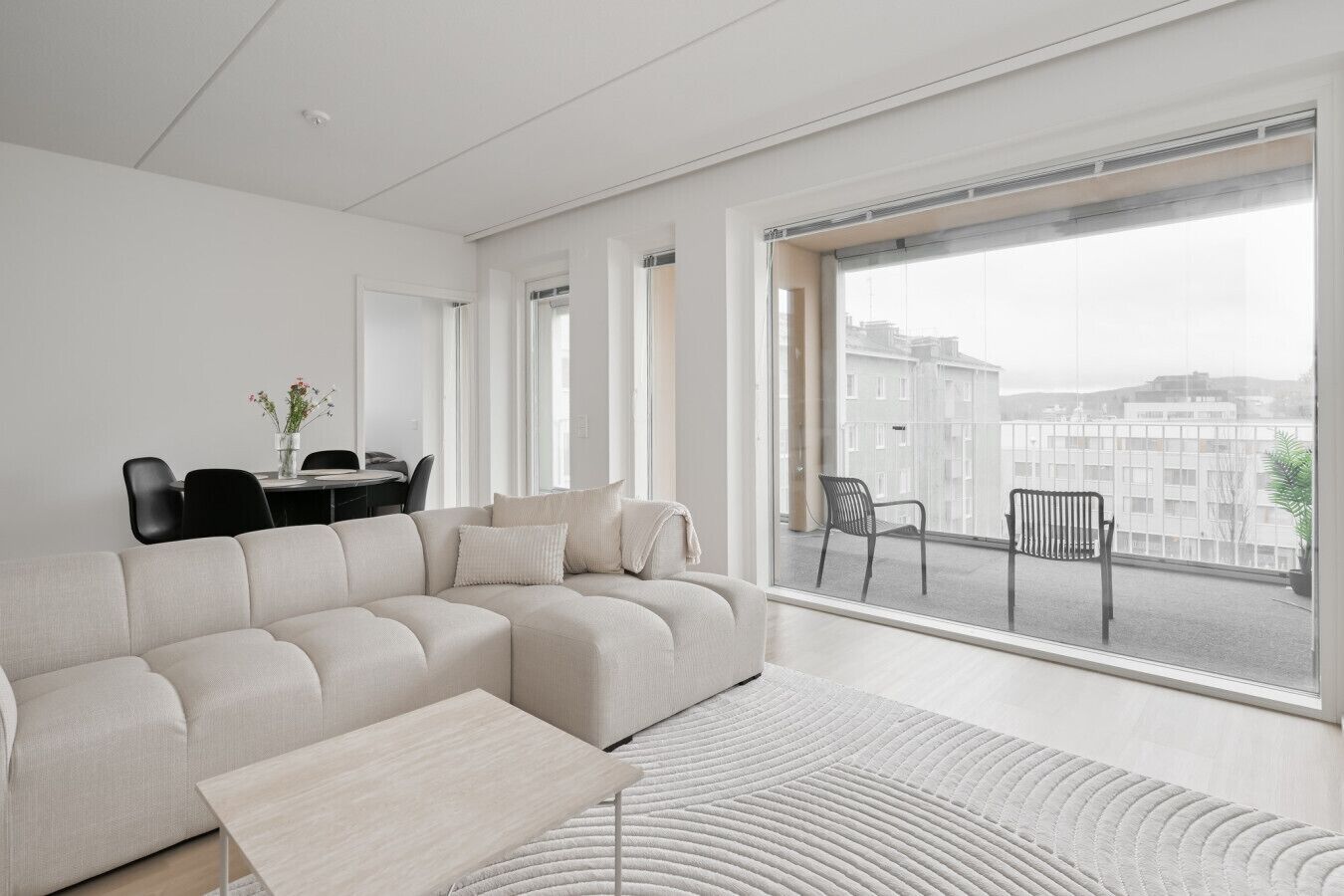 Un salon moderne comprenant un canapé, une table basse et un coin repas avec des chaises et une table.