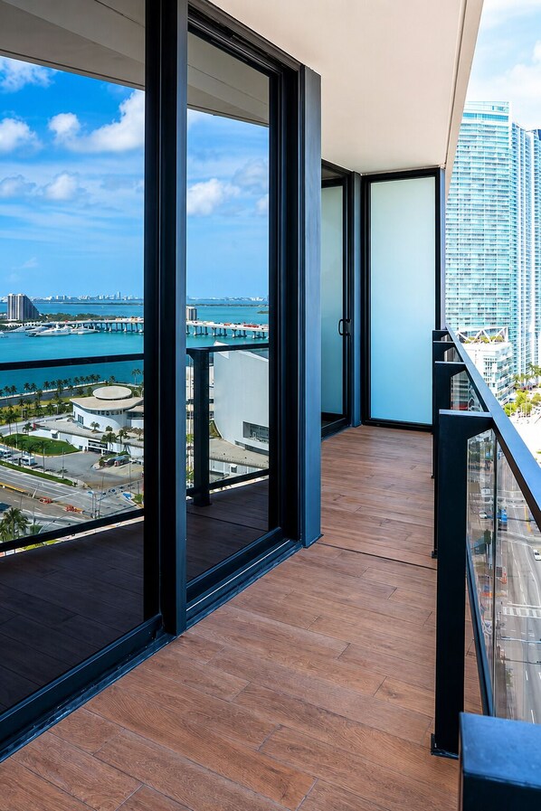 A balcony with a view of a cityscape and a bridge. - Stylish Ocean-View Condo in Downtown Miami (Miami)