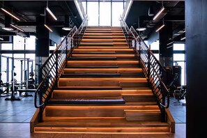 A staircase in a gym with metal railings and weightlifting equipment in the background. - Stylish Ocean-View Condo in Downtown Miami (Miami)