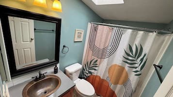 A bathroom with a sink, toilet, and shower curtain.