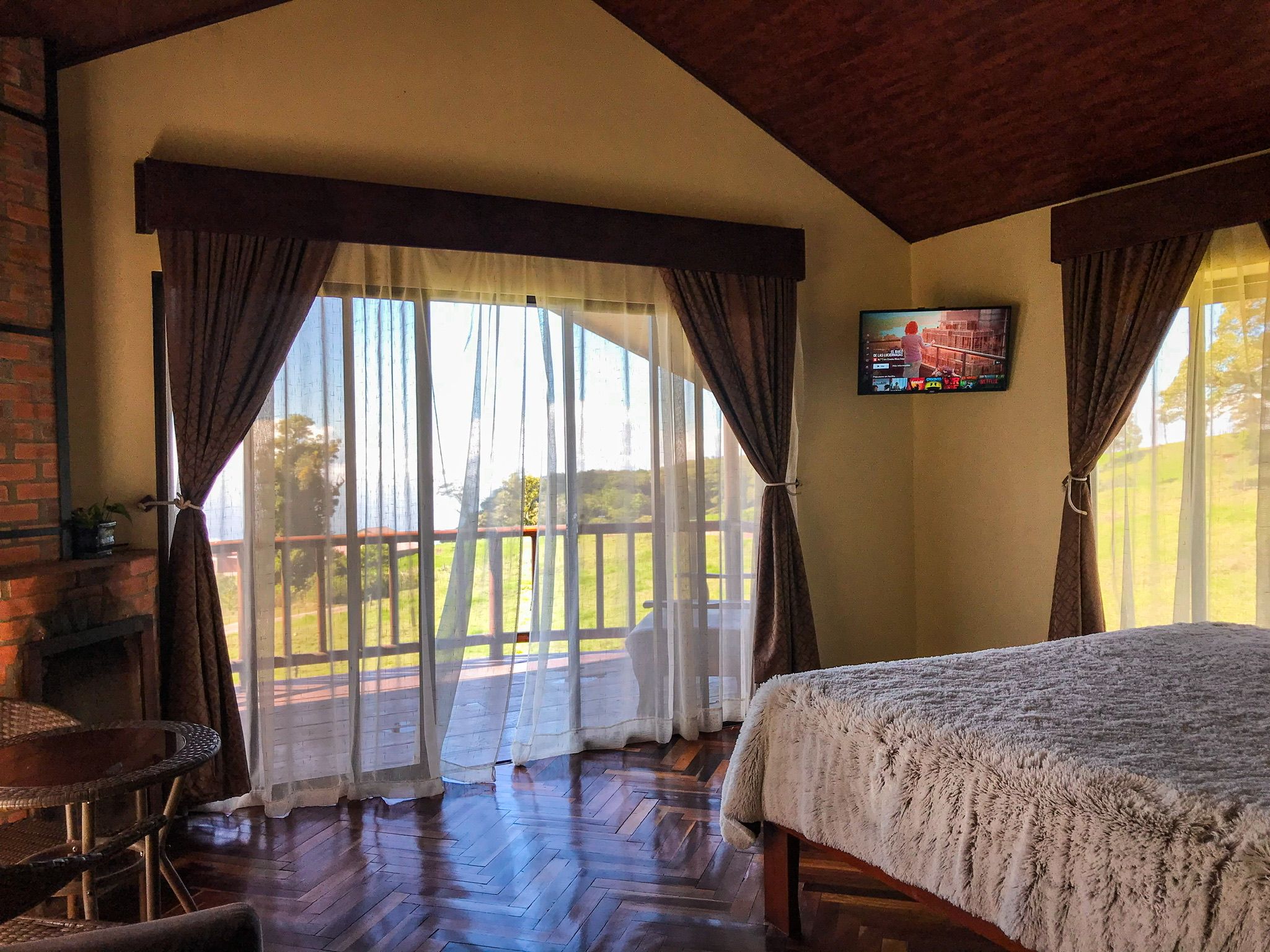 Una habitación con cama, televisión y vistas al exterior.