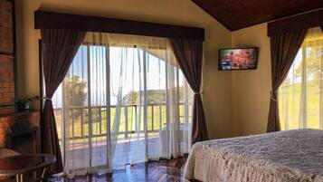 Una habitación con cama, televisión y vistas al exterior.