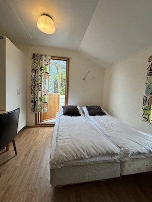 Ein Schlafzimmer mit Bett, Stuhl, Fenster und Deckenleuchte.