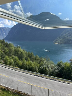 A coastal road with a view of a body of water and mountains in the distance.