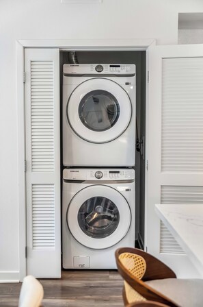 A laundry room with two stacked front-loading washing machines. - Casa Monica® Luxury 2BR in Irvine w/ Gym, Pool (Irvine)