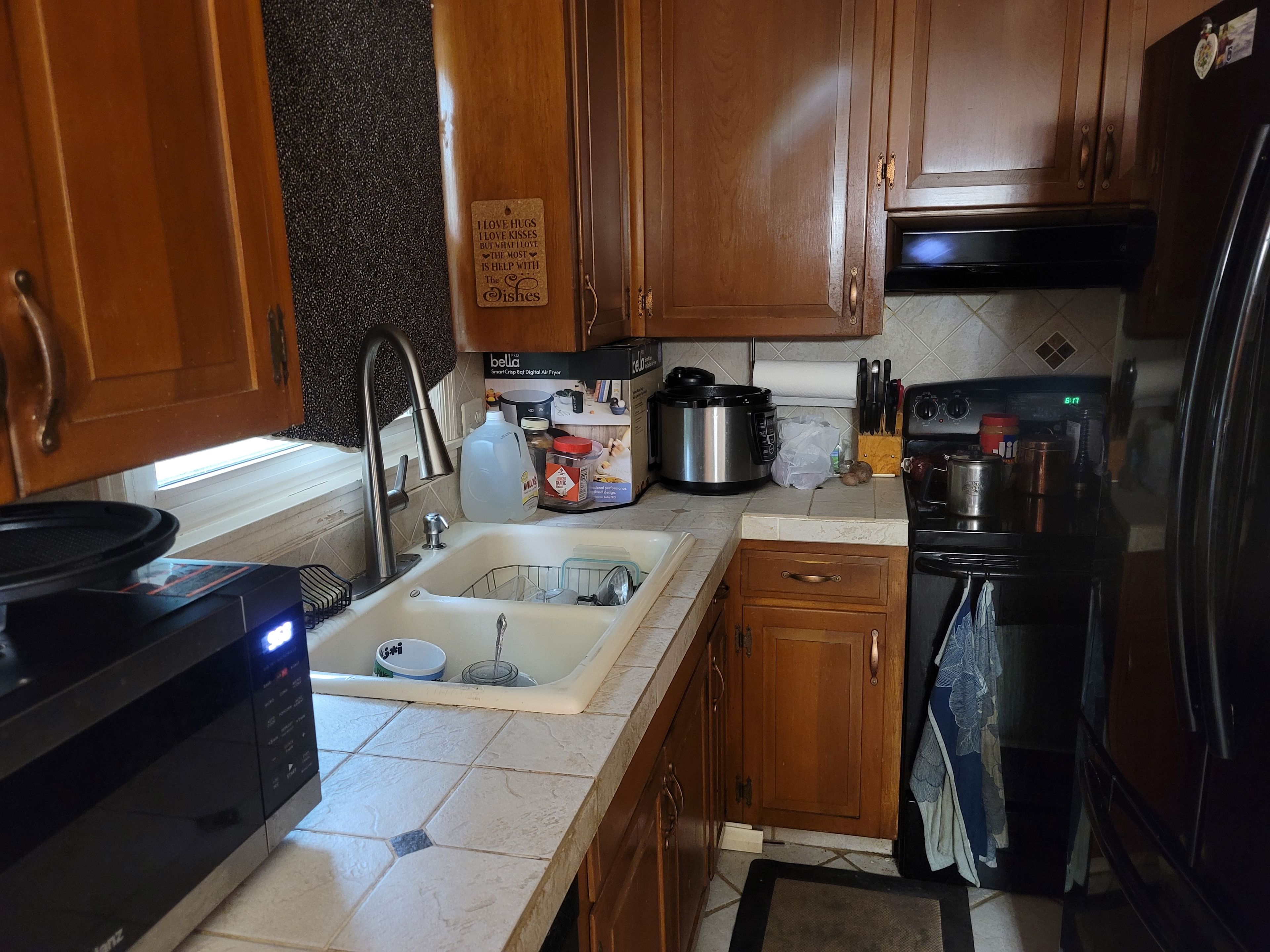 Una cocina con armarios de madera, un fregadero, una estufa y un refrigerador.