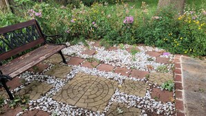 A garden with a bench and a paved area with stones and bricks. - Charming 3-bedroom house, fenced backyard and AC in brilliant Overland Park (Overland Park)