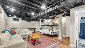 Una habitación amoblada con una cama litera, un sofá, una mesa de centro y un futón.