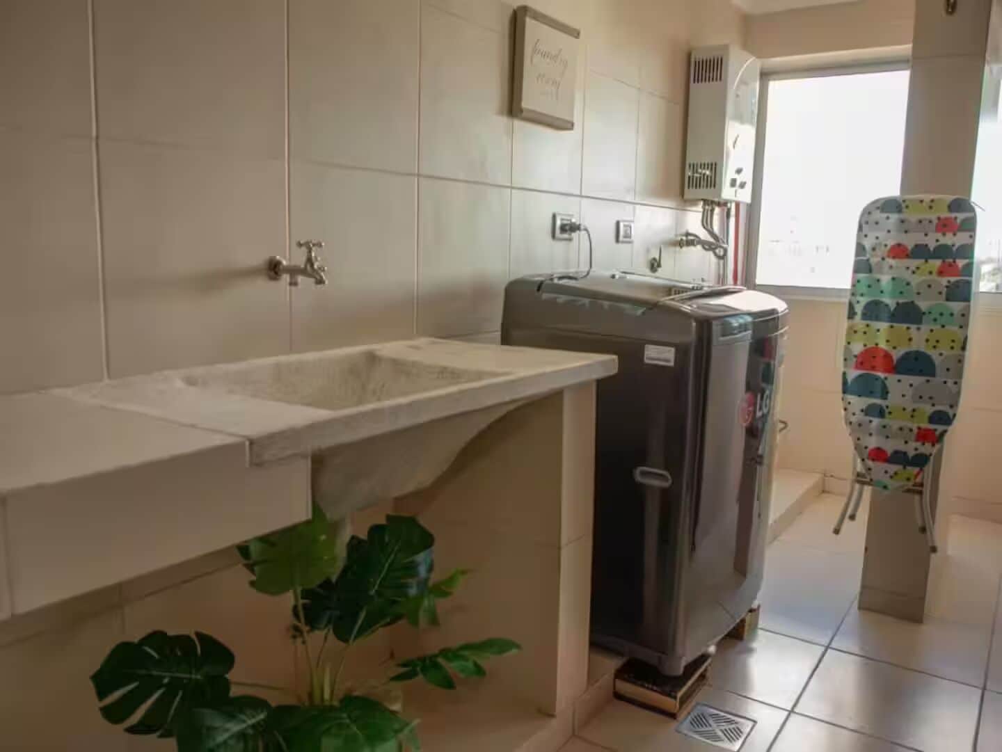 A bathroom with a sink, a towel rack, a heater, and a window.