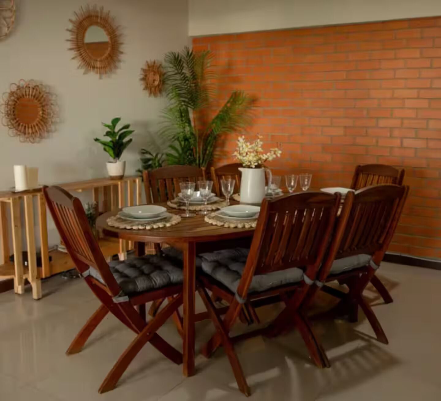 A dining area with a brick wall, wooden table, and chairs.