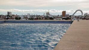 Ein Schwimmbecken mit Stadtblick im Hintergrund.