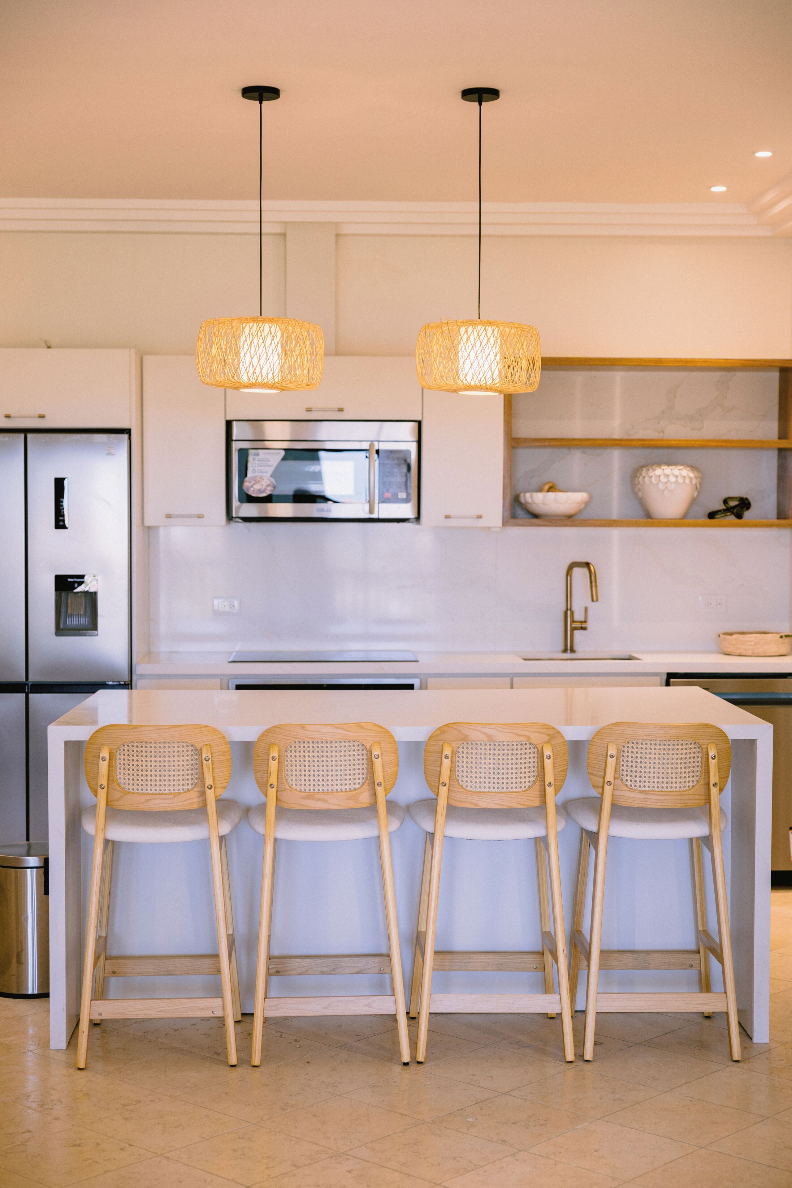 A modern kitchen with a central island, stainless steel appliances, and a microwave above the island.