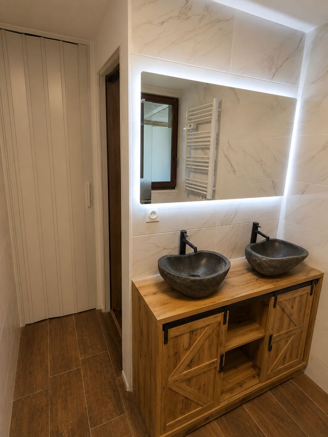 A bathroom with a wooden vanity, two vessel sinks, a mirror, and a towel rack.