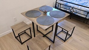 Uma mesa de jantar com quatro jogos americanos e dois bancos combinando.