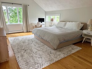 A bedroom with a bed, a desk, a chair, and a window. - 3-bedroom Coastal Narragansett Escape located in the heart of South County (Narragansett)