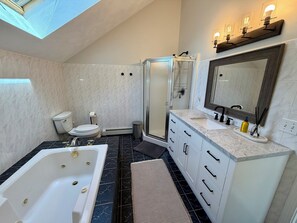 A modern bathroom with a bathtub, toilet, shower, and vanity. - 3-bedroom Coastal Narragansett Escape located in the heart of South County (Narragansett)