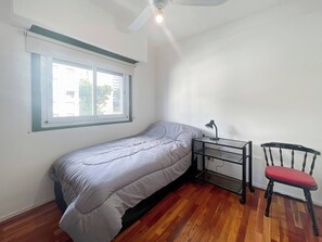 A small bedroom with a single bed, a desk with a chair, and a ceiling fan. - Beautiful 2 Bedrooms in the Heart of Palermo (Buenos Aires)