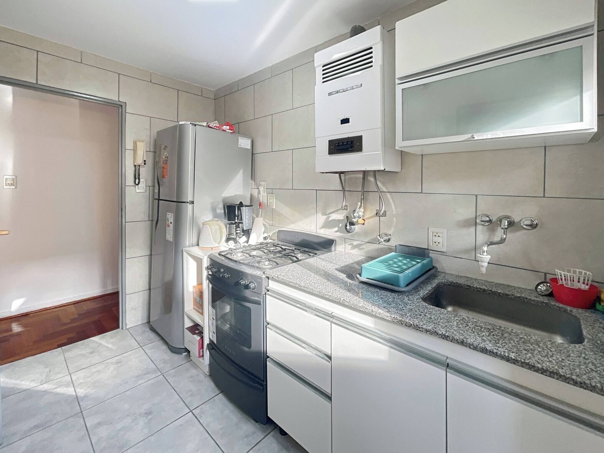 A modern kitchen with a gas stove, oven, refrigerator, and a built-in microwave.