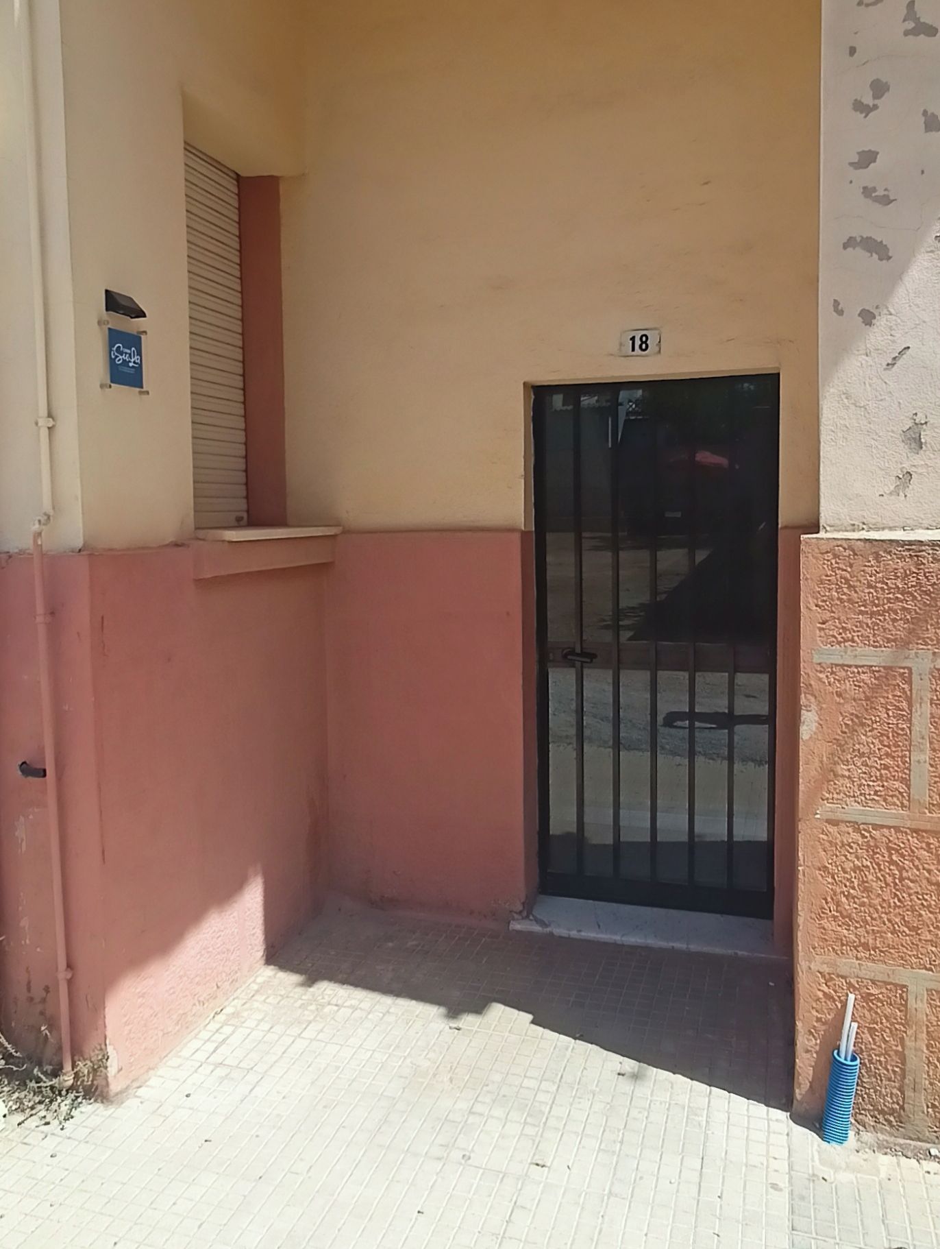 Ein Gebäude mit einem Eingangstor und der Hausnummer 18 über der Tür.