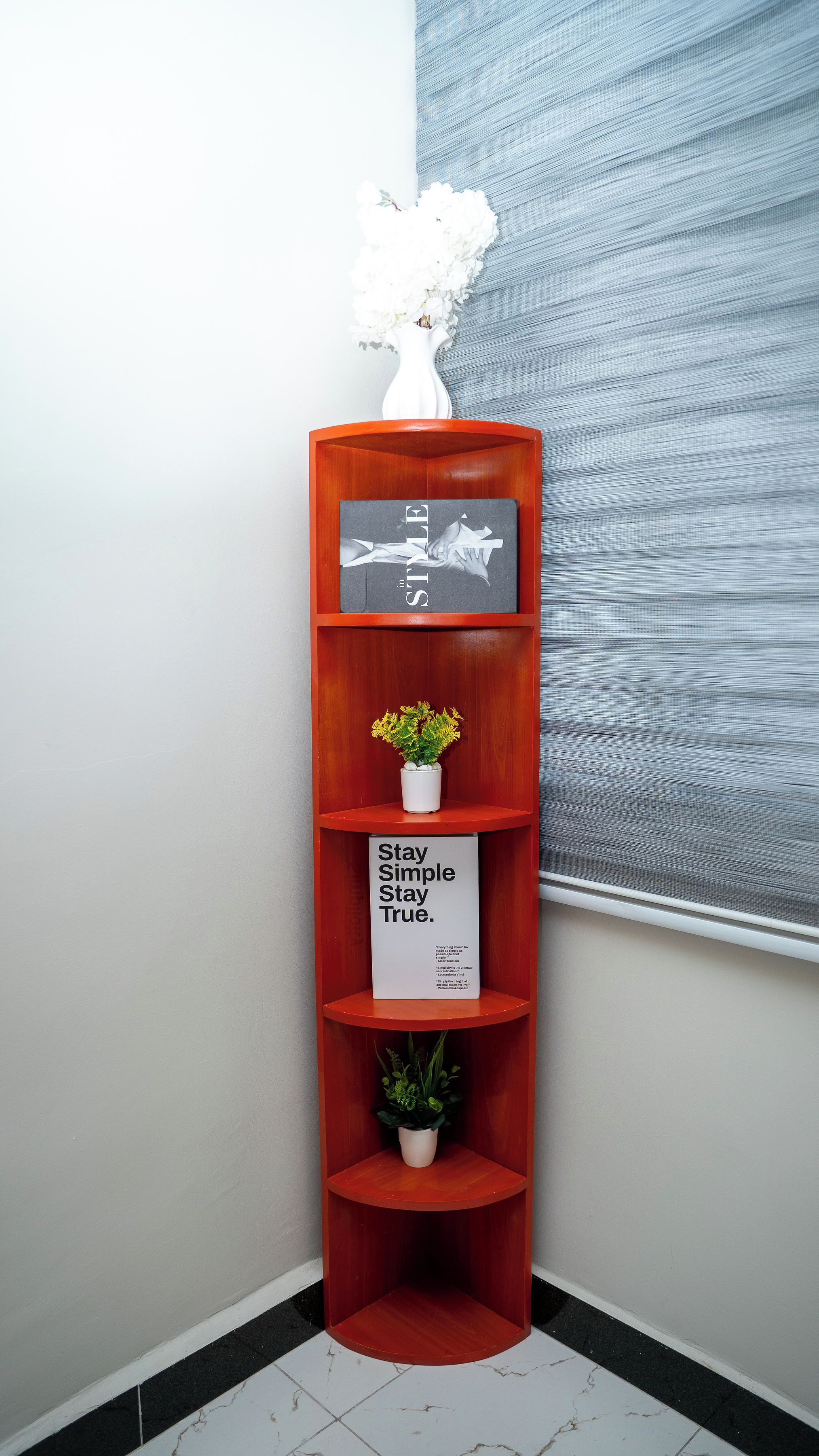 A corner shelf unit with multiple shelves, each holding decorative items.