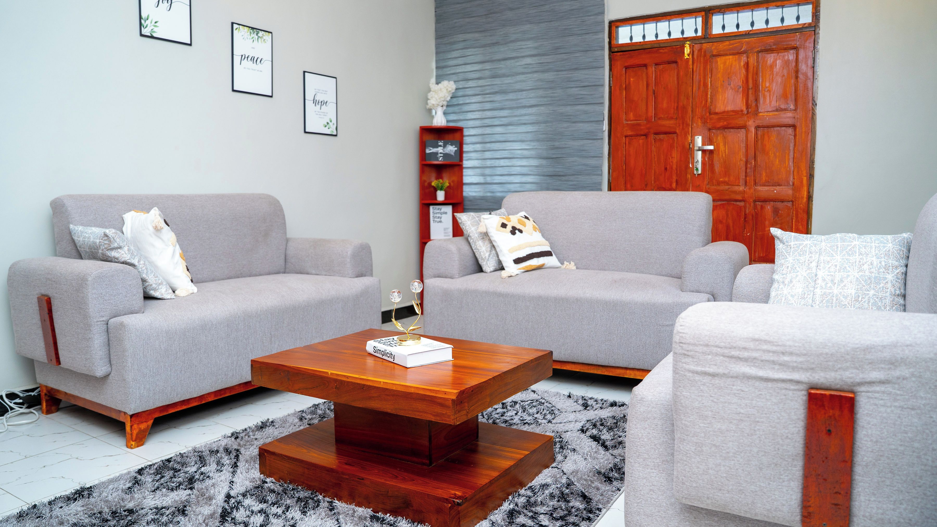 A living room with two grey sofas, a wooden coffee table, and a red wardrobe.