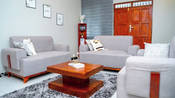 A living room with two grey sofas, a wooden coffee table, and a red wardrobe.