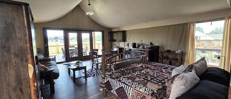 Une chambre spacieuse avec un grand lit, une armoire en bois, un bureau et un coin repas.
