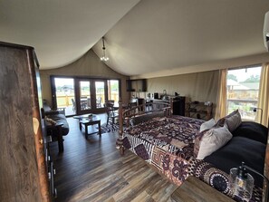 Un dormitorio amplio con una cama grande, un armario de madera, un escritorio y una zona de comedor.
