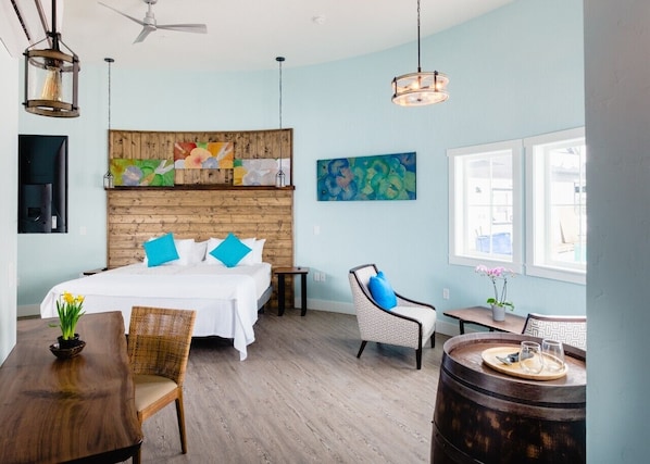 A hotel room with a bed, a dining table, a chair, a small table, and a wall-mounted artwork. - The Barn Walla Walla | Private 7-Suite Boutique Hotel (Walla Walla)