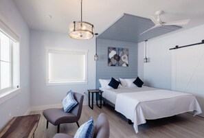 A modern bedroom with a bed, a chair, a desk, and a ceiling fan. - Vinifera Suite at The Barn | Boutique Hotel (Walla Walla)