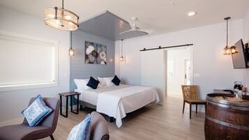 Una habitación de hotel moderna con cama, zona de estar y bar.