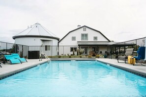 A swimming pool with lounge chairs and a fenced area. - Tannin Suite at The Barn | Boutique Hotel (Walla Walla)