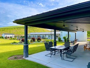 A covered patio area with outdoor furniture, a pool, and a view of a modern house with a well-maintained lawn. - Vendange Suite at The Barn | Boutique Hotel (Walla Walla)