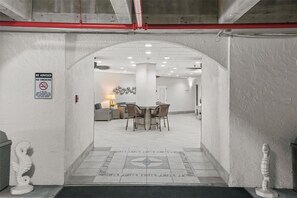 A hotel lobby with a dining area, a no-smoking sign, and a staircase leading to an upper level. - Seascape Towers 1025 (New Smyrna Beach)