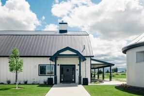 A modern house with a metal roof, a front porch, and a well-maintained lawn. - The Granary Suite at The Barn | Boutique Hotel (Walla Walla)