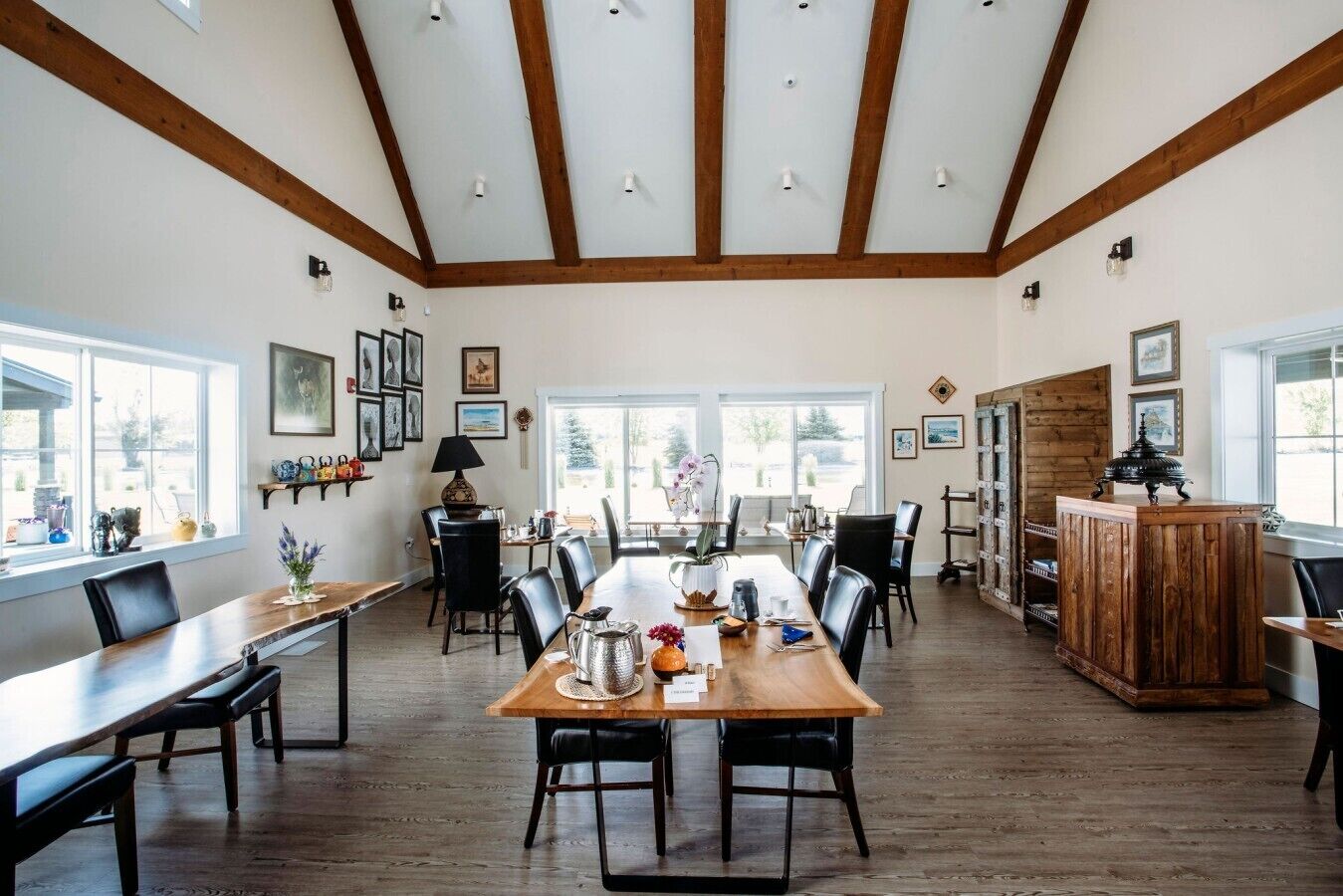 Un comedor amplio con una larga mesa de madera, varias sillas y un techo alto con vigas a la vista.