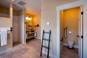 A bathroom with a shower, toilet, and a towel rack. - Loess Suite at The Barn | Boutique Hotel (Walla Walla)