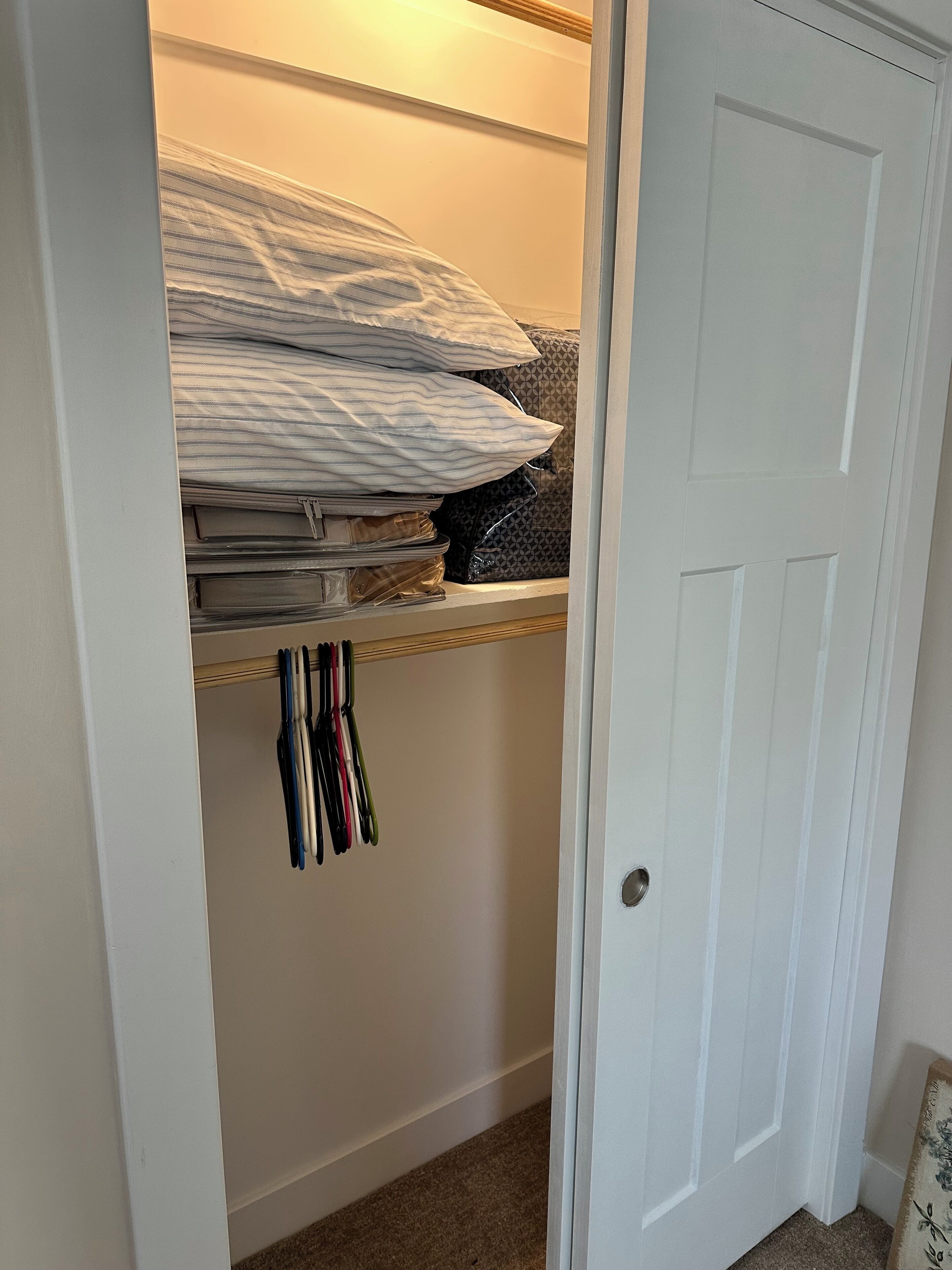 A closet with shelves, hanging storage, and a door.