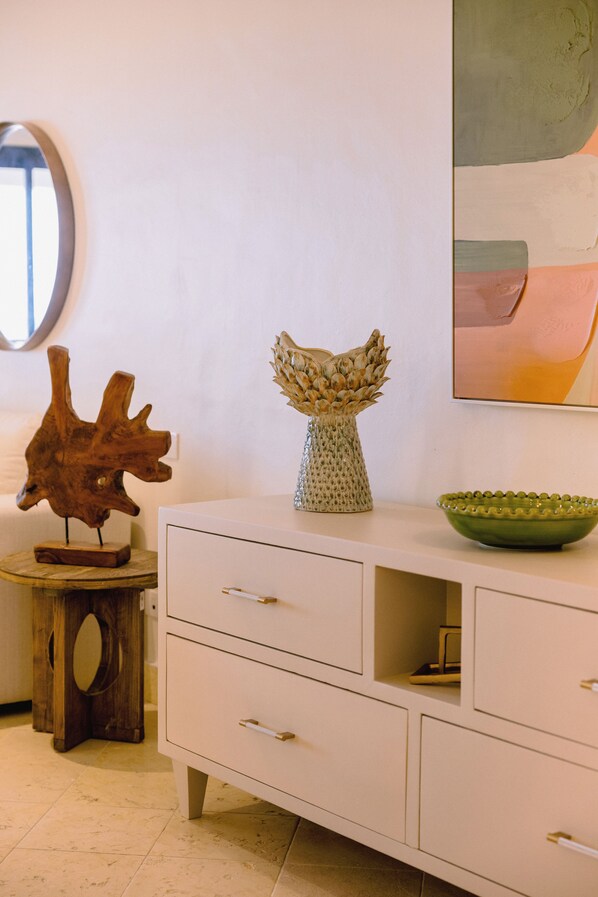 A white dresser with drawers, a vase, and a bowl on top.