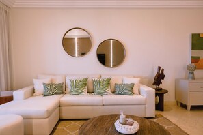 A living room with a sofa, two round mirrors, and decorative pillows.