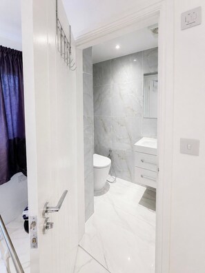 A modern bathroom with a toilet, sink, and shower area. - Spacious Garden Retreat w/ Free Parking Near Canterbury (Canterbury)