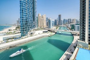 A high-rise building with a river running through the middle of a cityscape. - 52 42 Tower 1 (Dubai)