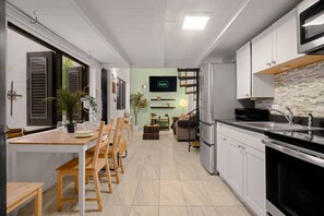 A modern kitchen with white cabinets, a black countertop, and a built-in oven. - Historic Loft in the Heart of Old San Juan (San Juan)