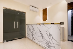 Una cocina moderna con encimera de mármol, refrigerador con puerta de vidrio y horno empotrado.