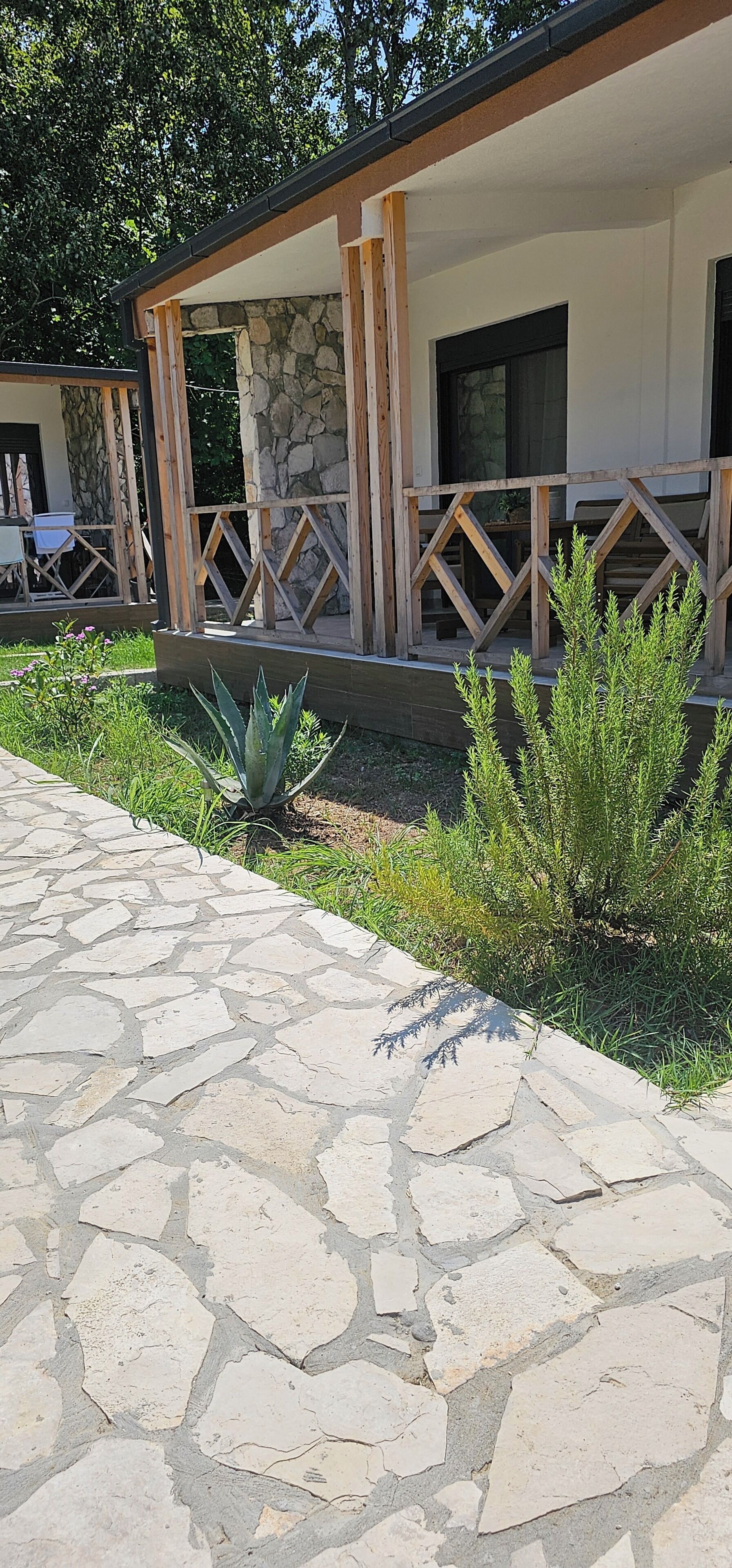 A stone-paved walkway leading to a building with a covered porch area.