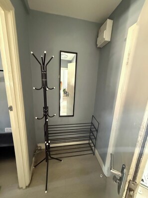 A hallway with a coat rack, a mirror, and a metal bench. - 2 Bedroom | Bedford | Stylish (Bedford)