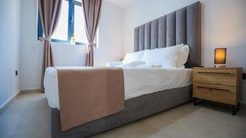 A bedroom with a bed, a bedside table, and curtains.